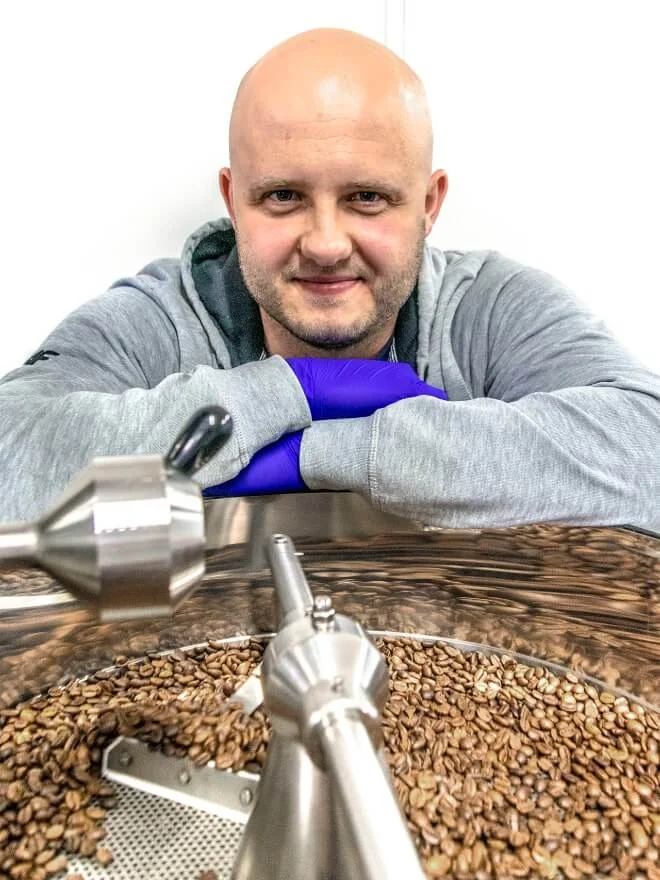 Adam Strógarek przy piecu w palarni Coffee Cave